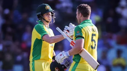 Australia's captain Aaron Finch (R) celebrates reaching his century with teammate Steve Smith during the one-day international cricket match against India at the Sydney Cricket Ground