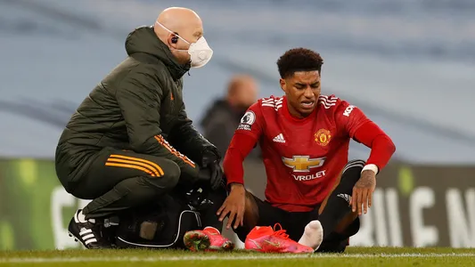A distressed Marcus Rashford of Manchester United with his injured ankle during the Premier League match at the Etihad Stadium
