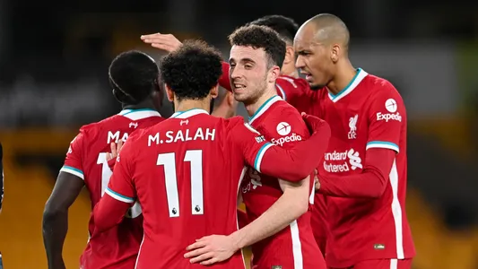 Liverpool's Diogo Jota, second right, celebrates with teammate Mohamed Salah after scoring his team's first goal during the English Premier League soccer match between Wolverhampton Wanderers and Liverpool at Molineux Stadium