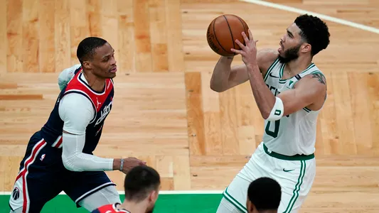 Boston Celtics forward Jayson Tatum (0) sets to shoot against Washington Wizards guard Russell Westbrook, left, during the second half of an NBA basketball Eastern Conference play-in game