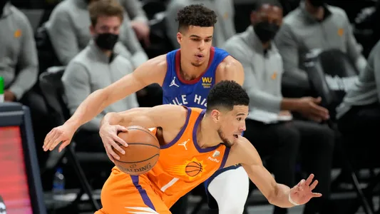 Devin Booker drives past Michael Porter Jr. during the second half of Game 3, second-round playoff series between the Phoenix Suns and Denver Nuggets, Friday, June 11, 2021