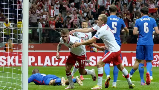 Poland's Damian Szymanski, left, celebrates after scoring his side's first goal during the World Cup 2022 group I qualifying soccer match between Poland and England