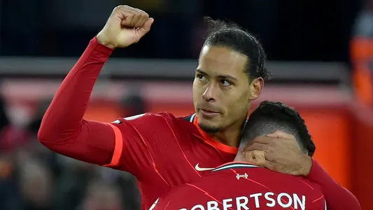 Liverpool's Virgil van Dijk celebrates with Andrew Robertson, right, after scoring his side's fourth goal during the Premier League soccer match between Liverpool and Southampton at Anfield