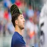 A pitcher looks on with a rally cap