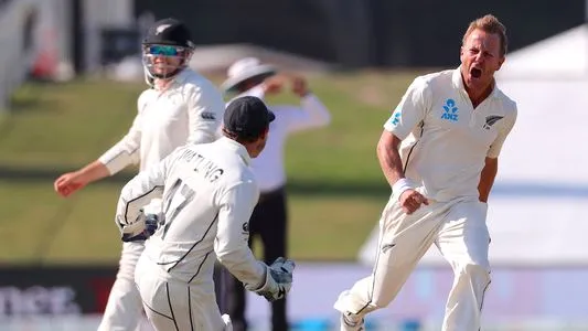 New Zealand's Neil Wagner (R) celebrates with teammate and wicketkeeper BJ Watling (C) after dismissing England's Stuart Broad to win the test match during the fifth day of the first cricket test between England and New Zealand at Bay Oval in Mount Maunga