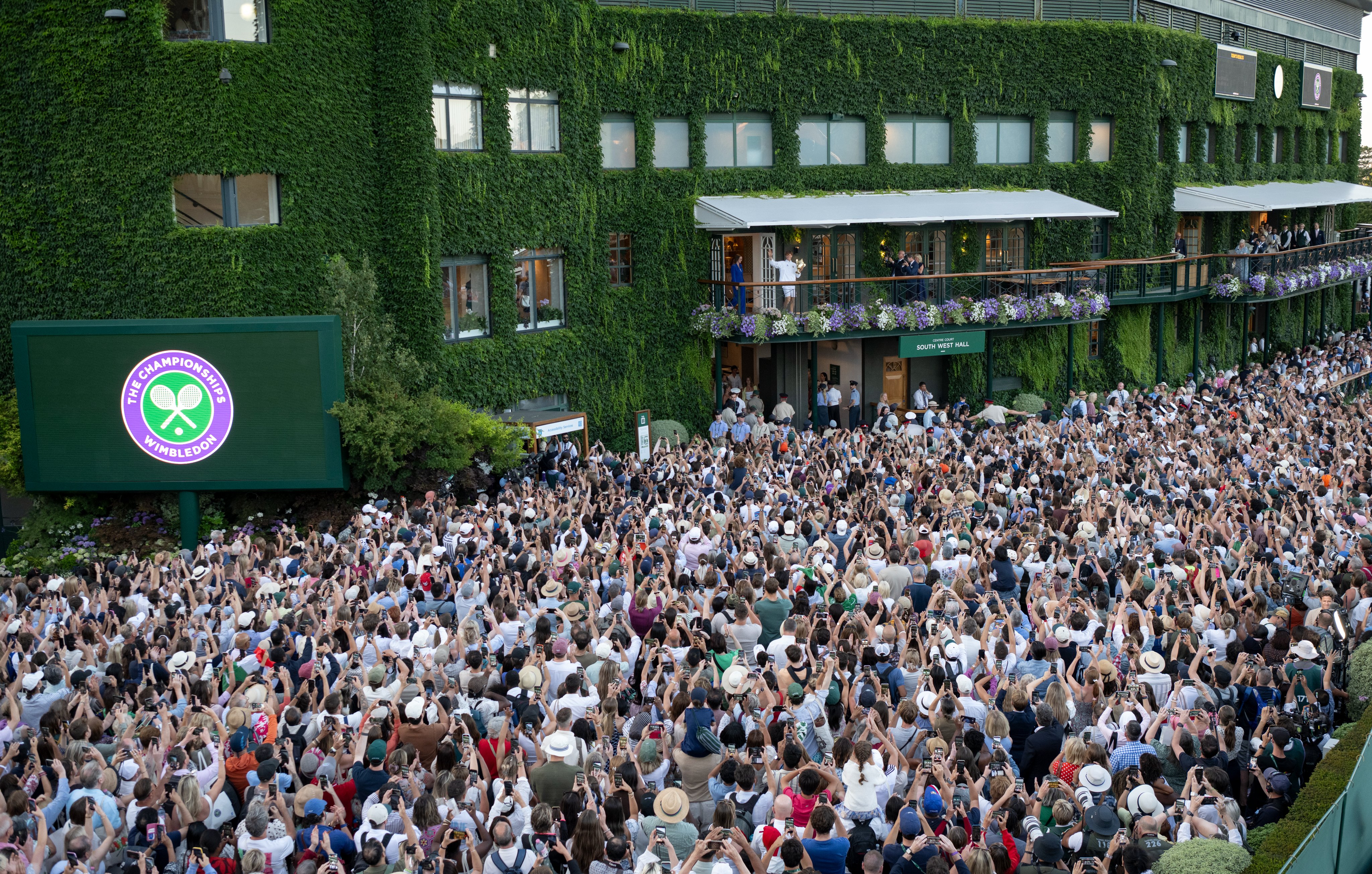 Wimbledon two-time champion Jannik Sinner out in the balcony with the trophy in hands at the All England Club. London, UK. July 12, 2026. Photo credit: The Championships.